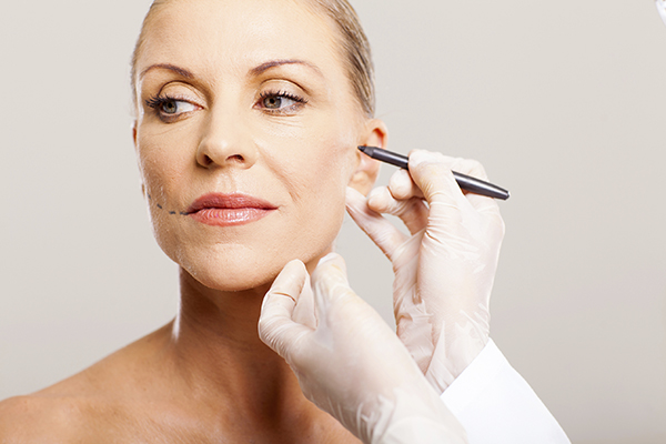 doctor correcting senior woman face